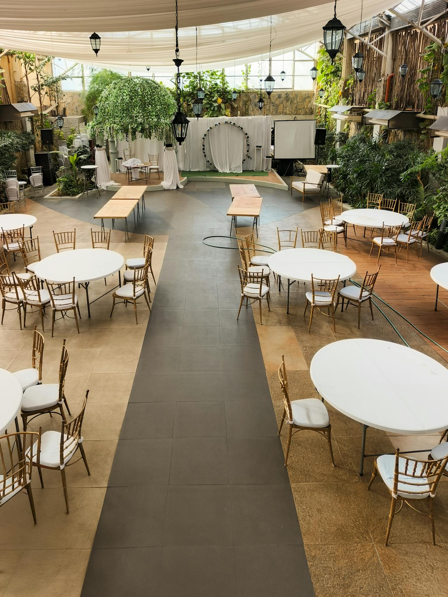 Spacious event venue with tables and chairs arranged for a gathering, featuring ample natural light.